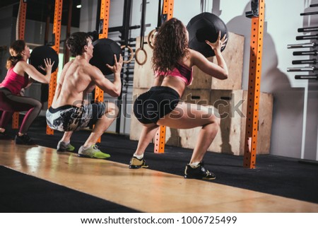 fitness, sport and exercising concept - group of people with medicine balls training in gym