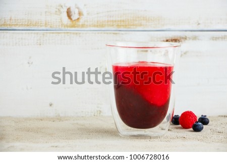 Double layered fruit smoothie mason jar with fresh berries, white wooden wall background, copy space, selective focus. Clean eating, vegetarian, weight loss, healthy, diet food concept
