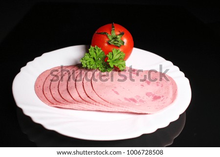 Round ham. Sliced pink ham meat on black reflective studio background. Isolated black shiny mirror mirrored background for every concept.