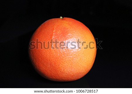Grapefruit. Whole orange big grapefruit on black reflective studio background. Isolated black shiny mirror mirrored background for every concept.
