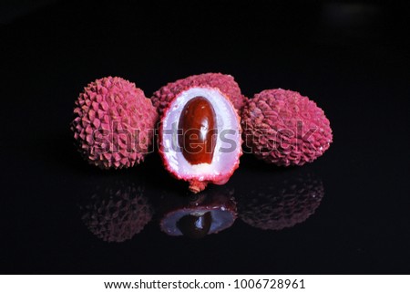 Litchi chinensis. Exotix litchi fruit fruits on black reflective studio background. Isolated black shiny mirror mirrored background for every concep