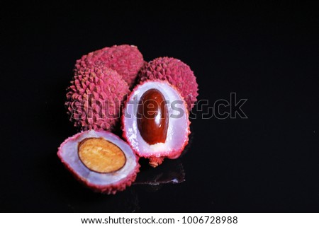 Litchi chinensis. Exotix litchi fruit fruits on black reflective studio background. Isolated black shiny mirror mirrored background for every concep