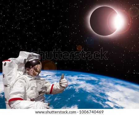 Astronaut against solar eclipse. The elements of this image furnished by NASA.
