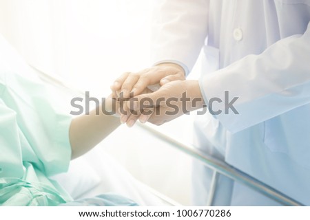 Doctor with patient. Routine health check and holding hands. Male medical doctor with young chinese woman. Royalty-Free Stock Photo #1006770286
