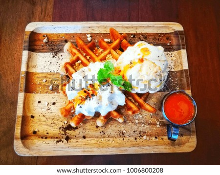 Thai tea waffle with vanilla ice cream and thai tea sauce on wooden plate 