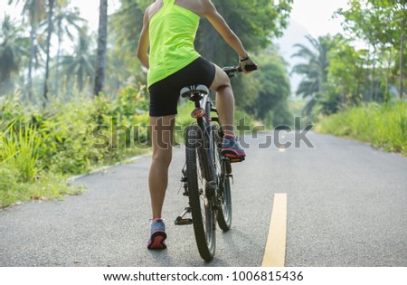 fitness woman cyclist cycling mountain bike on tropical forest trail