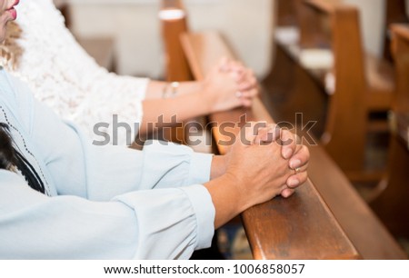 praying hands of two woman on seat at church ,Hands folded in prayer in church concept for faith,Spirituality and religion,Woman praying,