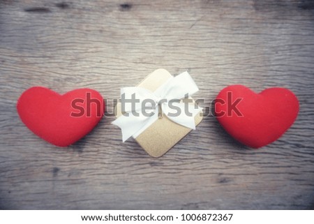 The red hearts and gift box on wooden