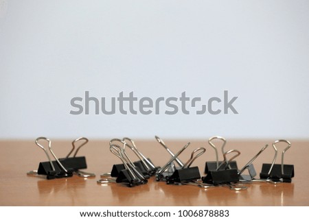 Black paper clip on brown table