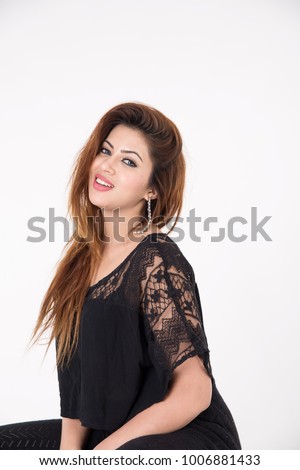 Young pretty girl in black dress posing on white background
