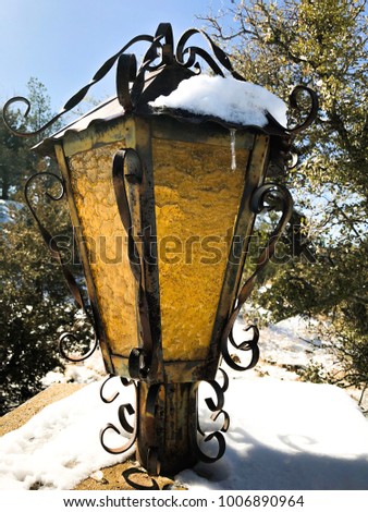Picture taken of a lantern after a light snow fall.