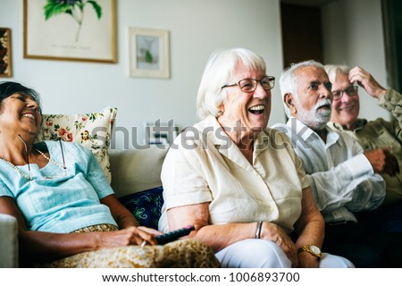 Senior people watching televison together Royalty-Free Stock Photo #1006893700
