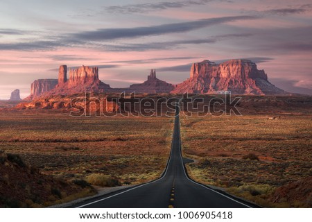 Forrest Gump Point, red rock at Monument Valley, Navajo Tribal Park, Arizona USA. Stunning view and scenic road in Utah during sunrise. Depth of long empty road. Royalty-Free Stock Photo #1006905418