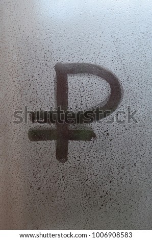 Symbol of the Russian ruble is written with a finger on the surface of the misted glass