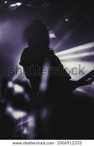 Silhouette of guitar player / guitarist perform on concert stage. Dark background, smoke, concert  spotlights