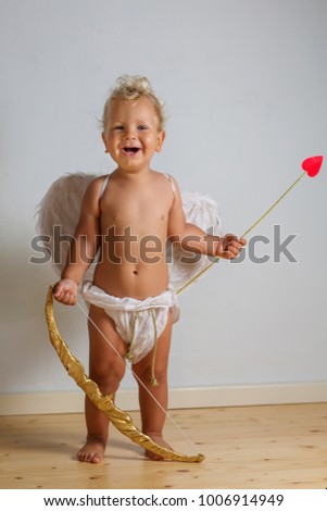 Small cupid is posing to the camera