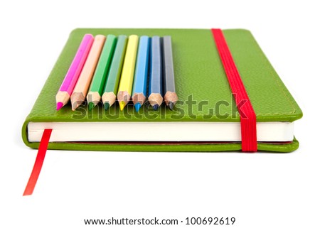 Notebook and pencils on white background