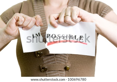 woman tearing the word impossible to turn into possible Royalty-Free Stock Photo #100696780