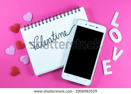 Valentine's day love Letter with notebook and smartphone on pink paper background with copy space.