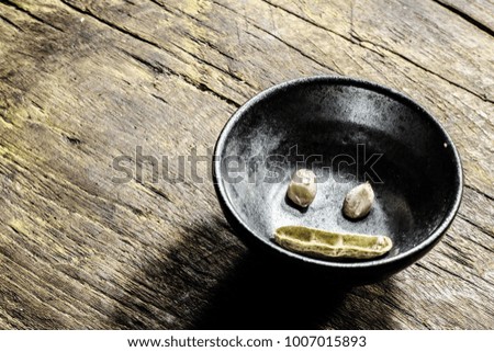 A smile of nuts. Bean in a wooden plate  on a vintage old background wood
