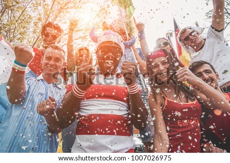 Multinational football supporters celebrating the begin of world competition - Happy multiracial people having fun together outside of stadium - Main focus on black man - Sport and bonding concept Royalty-Free Stock Photo #1007026975