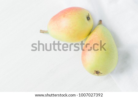 Couple of Ripe Organic Pears in Pastel Green Yellow Red Colors on White Wood and Linen Fabric. Elegant Minimalist Japanese Style. Creative Image for Social Media Blog Product Branding. Copy Space