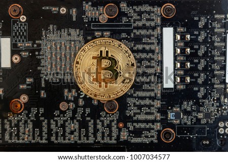Bitcoins lie on the video card, concept of mining. Electronic virtual money for web banking and international network payment. Symbol of crypto currency