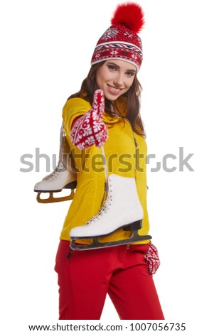 Smiling young woman carrying a pair of ice skates