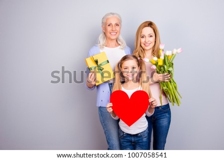 Positivity beauty care trust tenderness concept. Three family sweet cute adorable loving members holding heard package and beautiful flowers cuddling standing together isolated on gray background