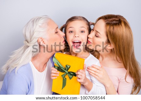 Celebration holiday trust care concept. Close up portrait of cheerful sweet cute tender gentle funny lovely little girl small girl getting package mom and granny kissing her isolated gray background