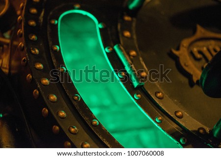 Abstract macro shot of vintage steam punk bronze home decor with green light 
