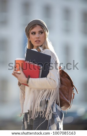 Portrait of beautiful young woman holding notebooks in student campus