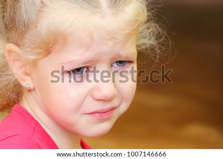Little crying curly girl portrait. Sad birthday.