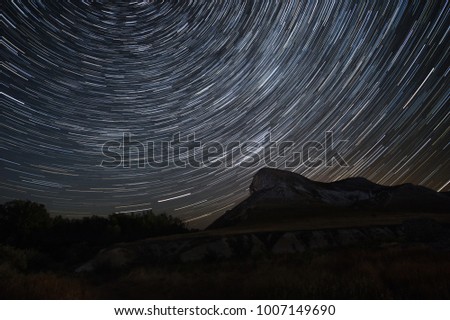 Beautiful star trails time-lapse over the hills. Polar Star at the center of rotation. Lateral light from the full moon on the chalk hills. 