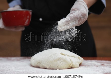 the cook makes flour out of flour for baking on the table