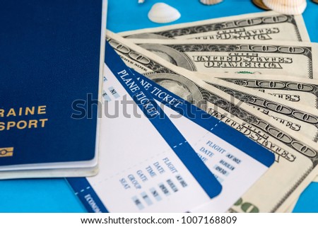 ticket with passport and dolls bills on blue