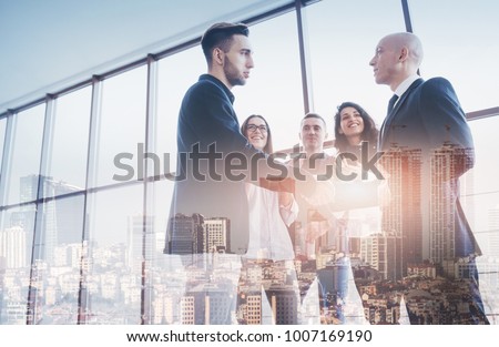 Two confident businessman shaking hands during a meeting in the office, success and partner concept. Double exposition, panorama of modern city. Royalty-Free Stock Photo #1007169190