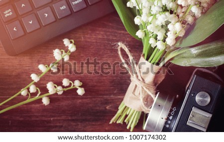 Bouquet of young lilies of the valley on a wooden table