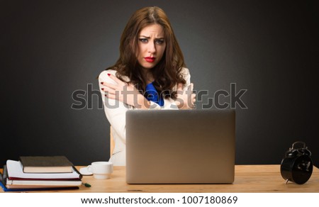 freezing business woman working with her laptop on black background