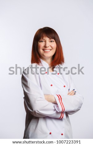 Picture of brunette chef in white robe with arms crossed at waist