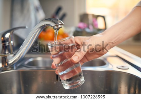 Pouring Fresh Tap Water Into a Glass  Royalty-Free Stock Photo #1007226595
