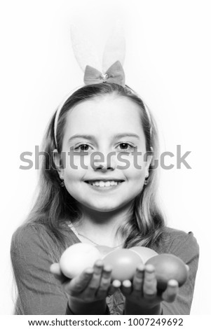 small baby girl or cute happy child wearing rabbit ears with pink blouse and holding colorful easter eggs isolated on white background