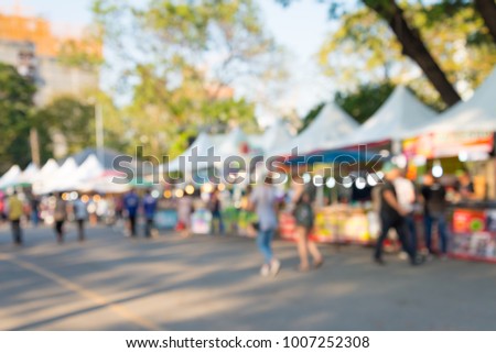 Blurred image of people in day market festival in city park background Royalty-Free Stock Photo #1007252308