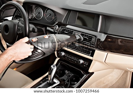 Portable car vacuum cleaner In action. Vacuums the car seats, interior, front pallets, doors. Ready product card. Without a logo. Royalty-Free Stock Photo #1007259466
