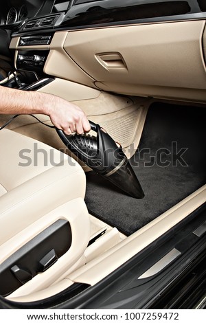 Portable car vacuum cleaner In action. Vacuums the car seats, interior, front pallets, doors. Ready product card. Without a logo. Royalty-Free Stock Photo #1007259472