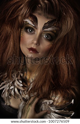 close up portrait of beautiful girl with feathers. professional makeup