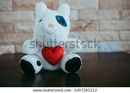 Cow doll holding a red heart shape, Valentine 's Day concept.