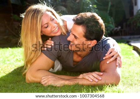 Close up portrait of fun pair lying on grass together in love