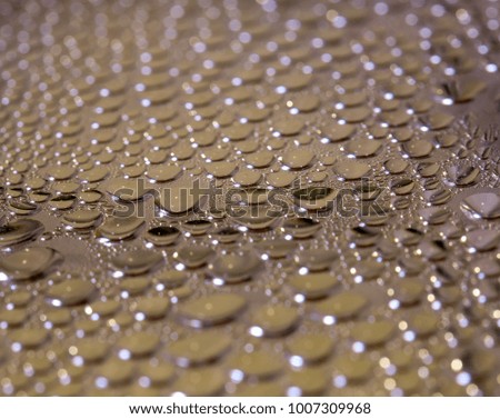 Background image where drops of water flow down a smooth surface.
