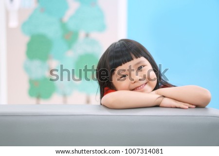 Asian children cute or kid girl happy fun and smile with wear red shirt on sofa at preschool or nursery and child hospital with space Royalty-Free Stock Photo #1007314081